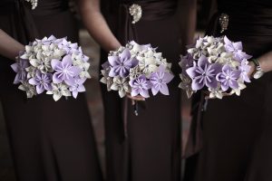 Three beautiful paper wedding flower bouquets on display.